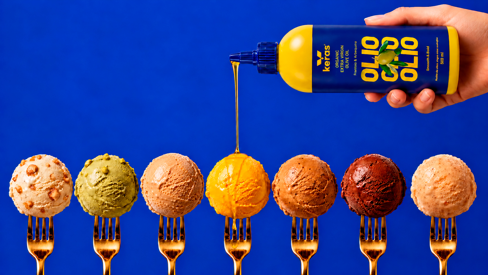 Aceite de oliva Keras cayendo sobre bolas de helado ensartadas en tenedores dorados